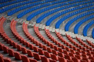 High angle view of red and blue rows of stadium bleachers showcasing repeating patterns.